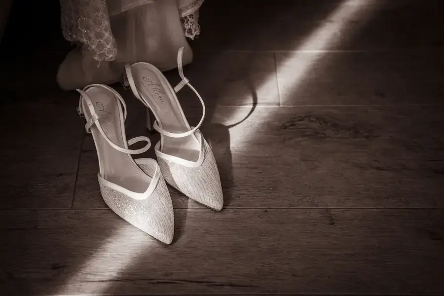 Le scarpe della sposa illuminate da una lama di luce