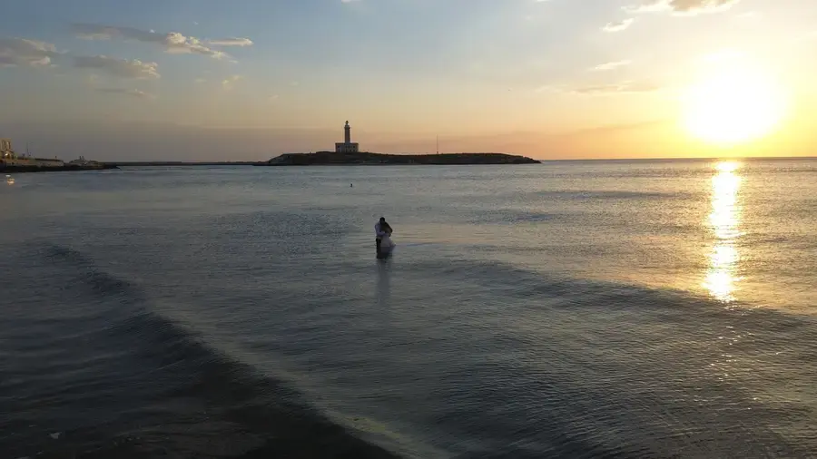 Veduta aerea della spiaggia con il faro all'alba