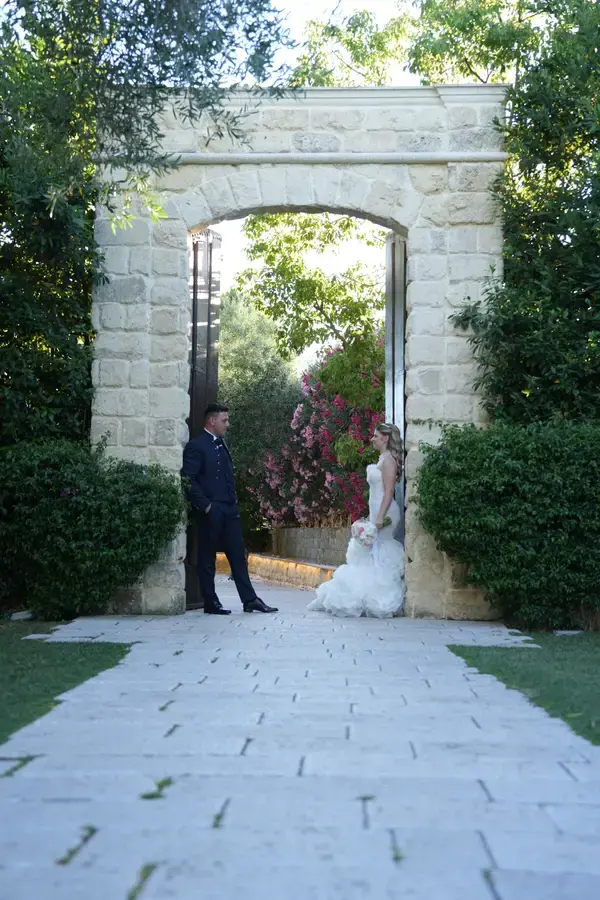 Gli sposi inquadrati nell'arco di pietra del giardino