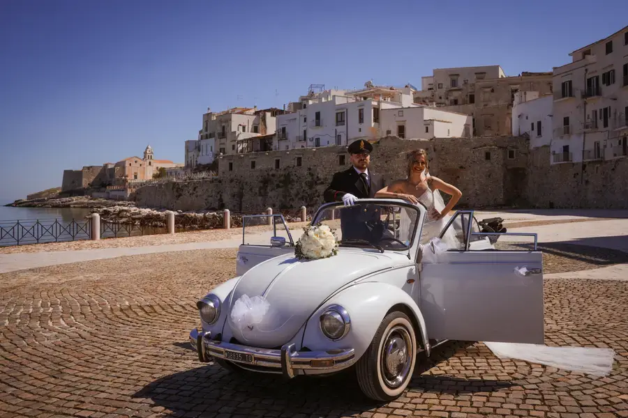 Maggiolone d'epoca sul lungomare del borgo affacciato sul mare