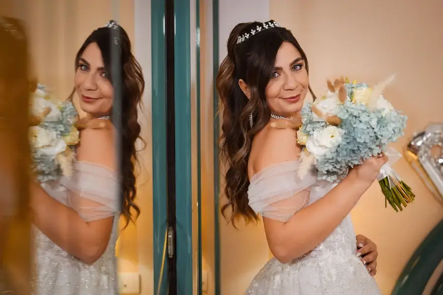 La sposa riflessa nello specchio mentre stringe il bouquet